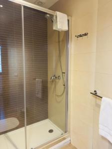 łazienka z prysznicem i szklanymi drzwiami w obiekcie Apartamentos Casa de La Inmaculada w Santiago de Compostela