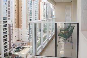 balcón con silla y vistas a la ciudad en Viva essa experiência! Jh Palhano, en Londrina