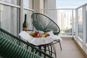 una cesta de comida y una botella de vino en una silla en Viva essa experiência! Jh Palhano, en Londrina