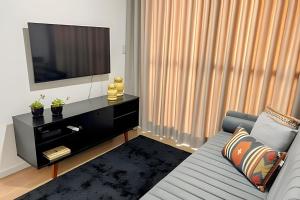 a living room with a couch and a flat screen tv at Moderno apto - vista maravilhosa in Londrina