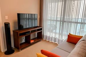 sala de estar con TV y sofá en Confortável&Único *JH Palhano, en Londrina