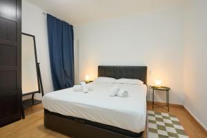 ein Schlafzimmer mit einem großen Bett mit weißen Laken und Kissen in der Unterkunft Park Guell in Barcelona