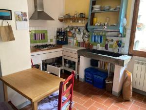 a kitchen with a table and a sink and a counter at Appartamento carino in Pescia +2 photos