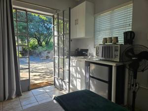 a kitchen with a microwave on a counter next to a door at Peace of Nature in Bloemfontein