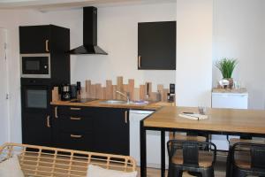 a kitchen with a table and a sink and a table and chairs at Sables Appartement in Condette