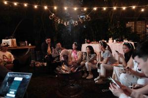un groupe de personnes assises dans une pièce éclairée dans l'établissement The Tiny Guesthouse, à Baguio