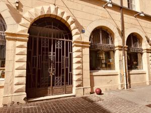 an entrance to a building with an iron gate at Le Tailleur, centre historique, fibre, climatisation, ESS, rez-de-chaussée, BedinShop in Romans-sur-Isère