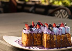 a piece of cake with fruit on top on a plate at The ENGLiSH Hotel, Las Vegas, a Tribute Portfolio Hotel in Las Vegas