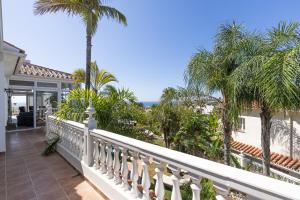 ein Balkon eines Hauses mit Palmen und dem Meer in der Unterkunft Villa Mariposa in La Cala de Mijas