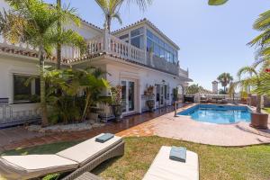 eine Villa mit Swimmingpool und ein Haus in der Unterkunft Villa Mariposa in La Cala de Mijas