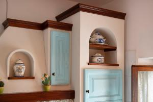 a room with turquoise doors and shelves with vases at Bellavista free parking city center in San Gimignano