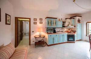 een keuken met blauwe kasten en een tafel met een lamp bij Bellavista free parking city center in San Gimignano