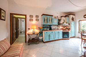 een keuken met blauwe kasten en een tafel met een lamp bij Bellavista free parking city center in San Gimignano +47 foto's