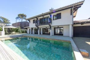dom z basenem przed domem w obiekcie VILLA DU PHARE au CAP FERRET w mieście Cap-Ferret