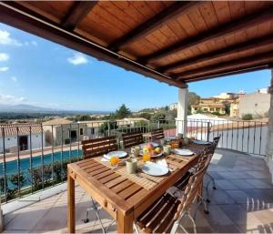 a wooden table on a patio with a view of a pool at La Turritta in Badesi