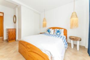 a bedroom with a large bed with blue and white sheets at Refúgio da Ria By ALGARTUR in Cabanas de Tavira