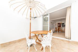 a dining room with a table and chairs and an umbrella at Refúgio da Ria By ALGARTUR in Cabanas de Tavira