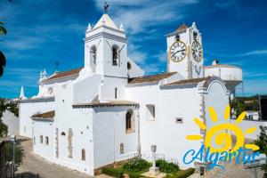 a large white church with a clock tower at Refúgio da Ria By ALGARTUR in Cabanas de Tavira
