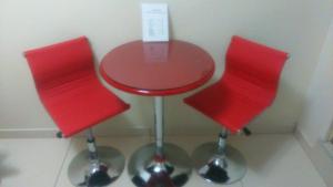two red chairs and a red stool next to a table at Hostal Onassis in Lima +6 photos