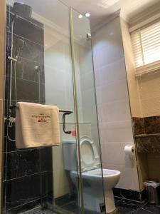 a bathroom with a toilet and a glass shower at The Sojourner By Genesis in Ikeja