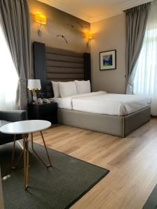 a hotel room with a large bed and a table at The Sojourner By Genesis in Ikeja