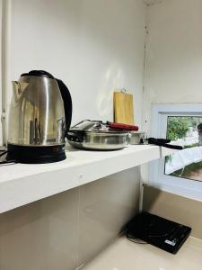 a kitchen shelf with a pot and pans on it at Apartment Wat Sawang Arom 35 in Amphoe Koh Samui +20 photos