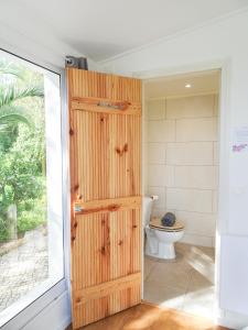 une salle de bain avec toilettes et porte en bois dans l'établissement Quinta de Lagos, à Lagos