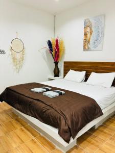 a bedroom with a large bed with a brown blanket at Apartment Wat Sawang Arom 35 in Amphoe Koh Samui
