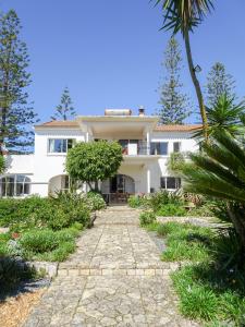 une grande maison blanche avec un palmier dans l'établissement Quinta de Lagos, à Lagos