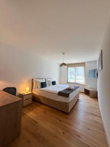 una camera da letto con un grande letto e una finestra di Boutique hôtel Corbetta & SPA - A 5 minutes de l'autoroute A12 aux Paccots sur Montreux, profitez de la montagne et du lac Léman- LOFT FAMILIAL DISPONIBLE a Les Paccots Altre 69 foto