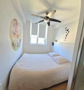 a bedroom with a bed with a ceiling fan at Les bons Enfants 5 in Rouen