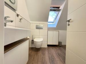 ein Badezimmer mit Toilette und Fenster in der Unterkunft Padua W05 in Cuxhaven + 14 Fotos