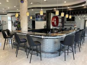 a bar in a restaurant with black bar stools at The Streamline Hotel - Daytona Beach in Daytona Beach