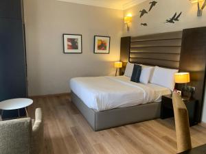 a bedroom with a bed and a table and a chair at The Sojourner By Genesis in Ikeja