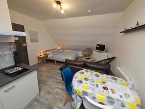 a small living room with a bed and a table at Studios du Cèdre in Cuvilly