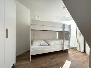 ein weißes Etagenbett in einem weißen Zimmer in der Unterkunft Padua W05 in Cuxhaven
