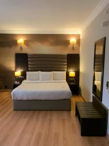 a bedroom with a large bed and two lamps at The Sojourner By Genesis in Ikeja