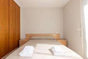 Un dormitorio con una cama con dos toallas encima. en Rentalmar Residencial La Cala, en Miami Platja 40 fotos más