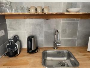 a kitchen counter with a sink and a coffee maker at Studio Den Burg in Den Burg