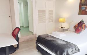 a bedroom with a bed and a desk and a chair at HABITACION 116 cómoda independiente con baño y balcón privado Unicentro norte in Bogotá +28 photos