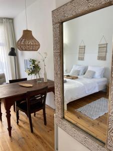 a mirror reflecting a bedroom with a bed and a table at Studio Den Burg in Den Burg