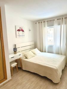 una camera da letto bianca con un letto e una scrivania di Comfortable apartment with 2 bedrooms and Pool a Torrevieja Altre 37 foto
