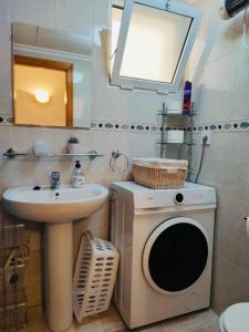 un bagno con lavandino e lavatrice di Comfortable apartment with 2 bedrooms and Pool a Torrevieja