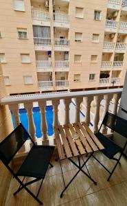 un balcone con tavolo e sedie e un edificio di Comfortable apartment with 2 bedrooms and Pool a Torrevieja