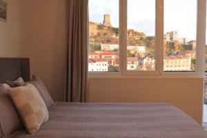 a bedroom with a bed with a view of a city at Pisha Panoramic Rooms in Krujë