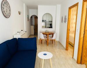 un soggiorno con un divano blu e un tavolo di Comfortable apartment with 2 bedrooms and Pool a Torrevieja
