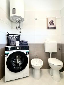 a bathroom with a washing machine and a toilet at Apartments Terra Solaris in Medulin