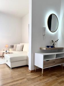 a living room with a white couch and a mirror at Apartments Terra Solaris in Medulin