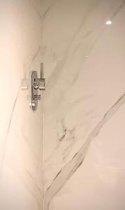 pared de mármol blanco y baño con ducha. en Apartamento na cidade de Luanda, Mutamba, Angola, África, en Luanda