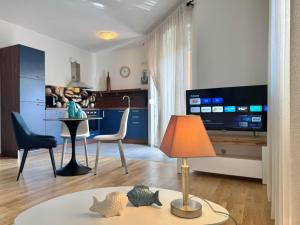 a living room with a table with a lamp and chairs at Apartments Terra Solaris in Medulin